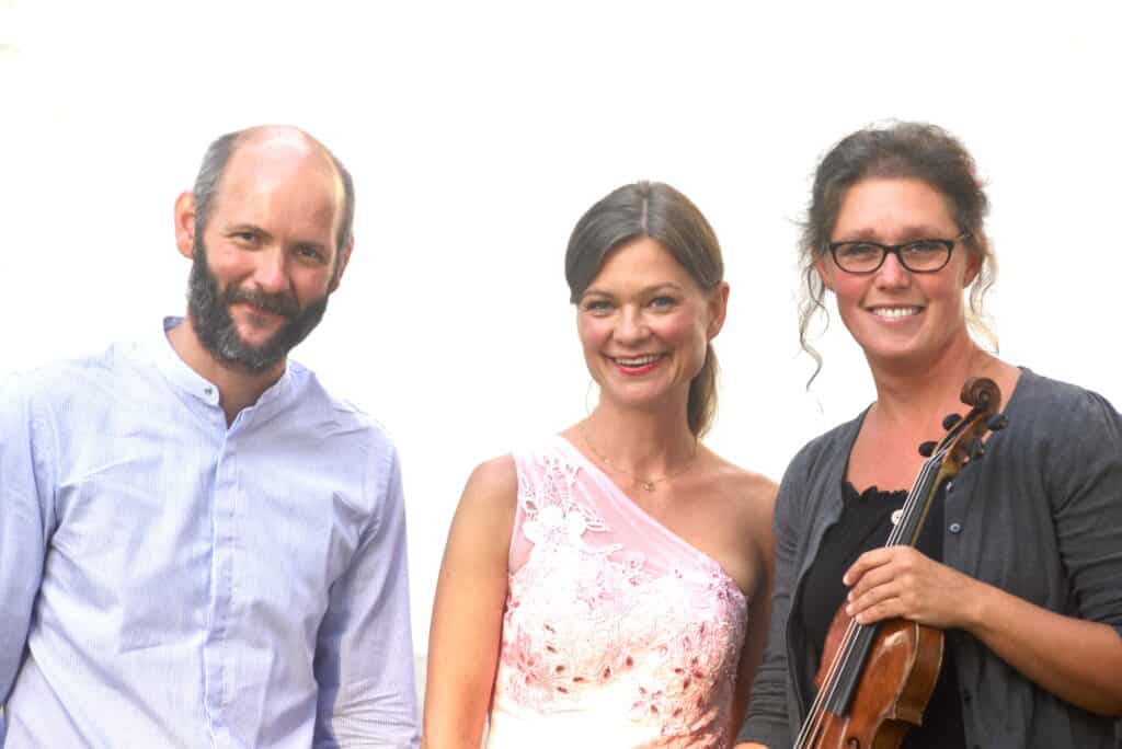 Bild på Anders Emtell, Petra Valman och Elin Emtell Rubinzstein. Elin håller i sin violin. Denna trio gör Musik i sommarkväll tillsammans.