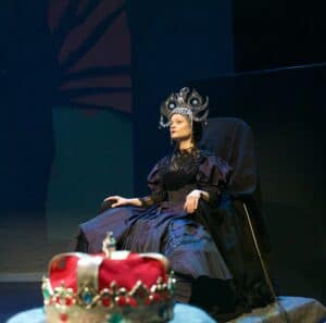 Queen of the night sitting in her chair beside the king's crown